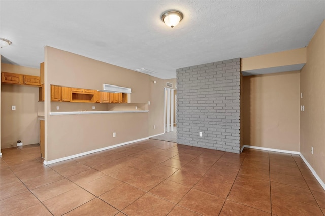 unfurnished living room featuring light tile patterned flooring, baseboards, and a textured ceiling