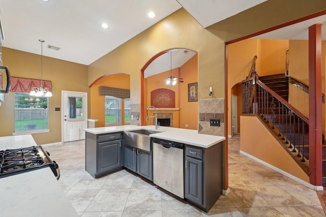 kitchen featuring dishwasher, a fireplace, gray cabinetry, and a sink