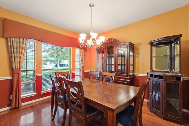 dining area with wood finished floors, baseboards, and a chandelier