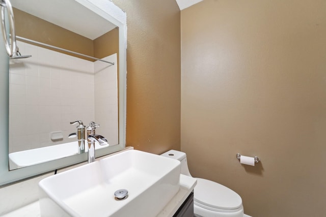 bathroom featuring toilet, a shower, and a sink