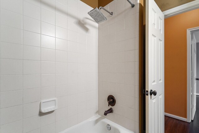 full bath with wood finished floors, baseboards, and shower / bathtub combination