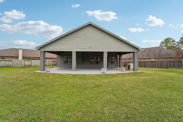 rear view of house with a patio area, a lawn, and a fenced backyard