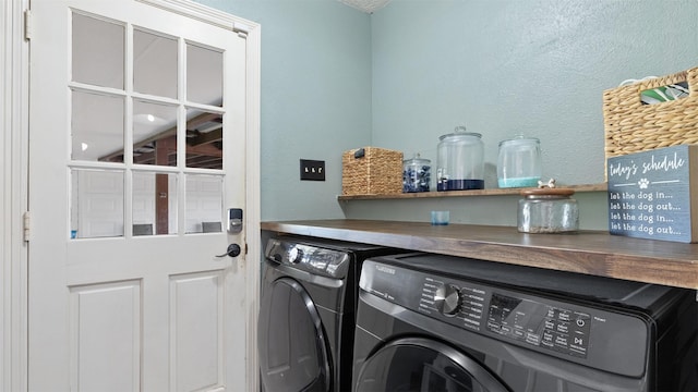 laundry room featuring separate washer and dryer, laundry area, and a textured wall