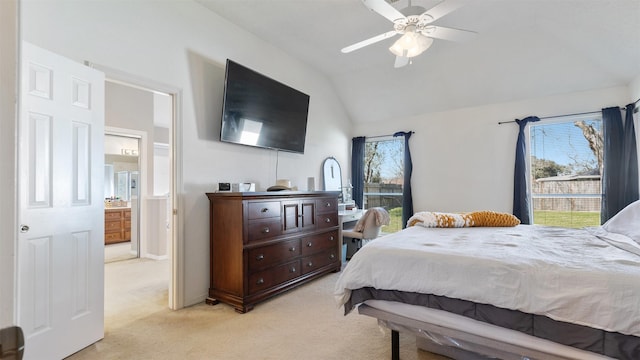 bedroom with light colored carpet, ensuite bath, ceiling fan, and vaulted ceiling