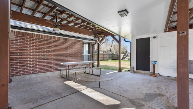 view of patio / terrace with fence, a garage, and ceiling fan