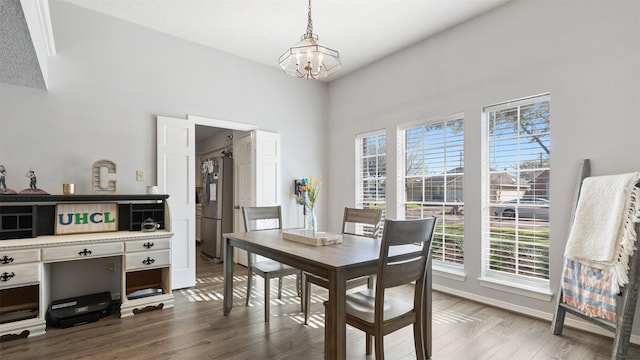 dining space with a notable chandelier, baseboards, and dark wood-style flooring