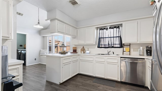 kitchen with visible vents, appliances with stainless steel finishes, a peninsula, and white cabinets