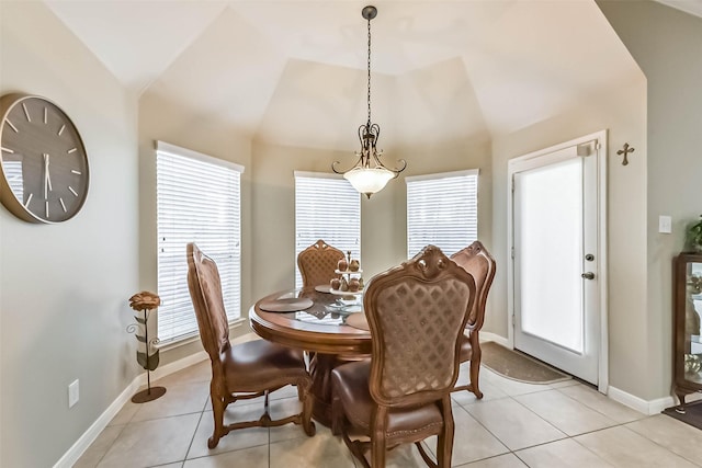 dining room featuring lofted ceiling, light tile patterned flooring, and baseboards