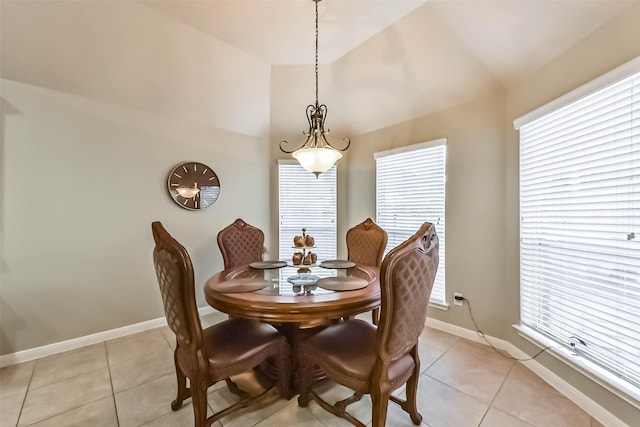 dining room featuring vaulted ceiling, light tile patterned flooring, and baseboards