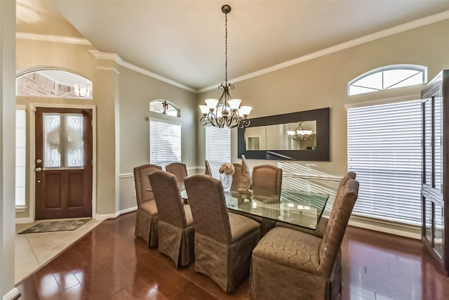 dining room with hardwood / wood-style flooring, a notable chandelier, a healthy amount of sunlight, and ornamental molding