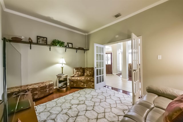 living area featuring visible vents, french doors, wood finished floors, and ornamental molding