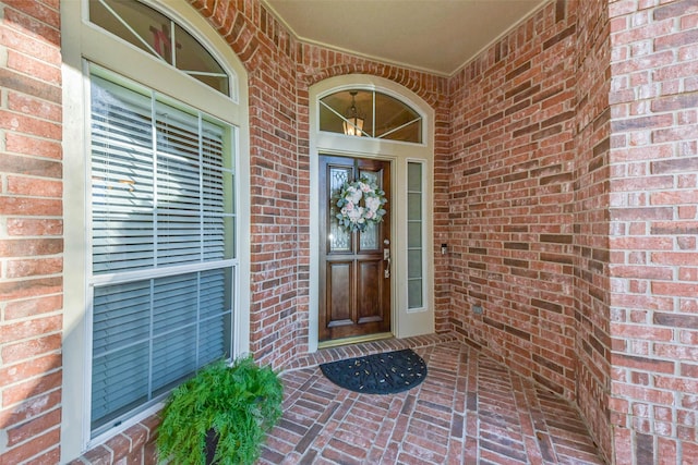 doorway to property featuring brick siding