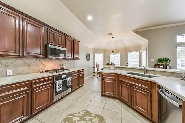 kitchen with tasteful backsplash, appliances with stainless steel finishes, light countertops, and a sink