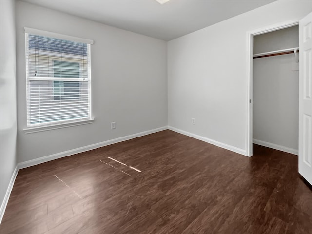 unfurnished bedroom with a closet, baseboards, and wood finished floors