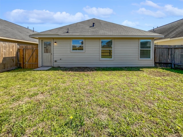 back of property with a lawn and a fenced backyard