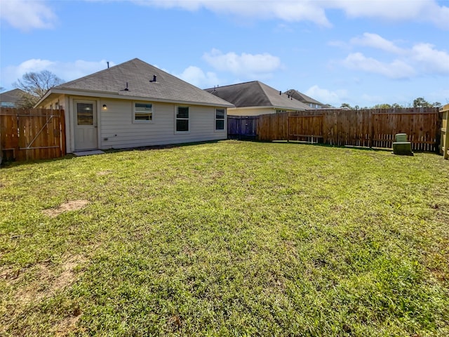 back of property featuring a fenced backyard and a yard