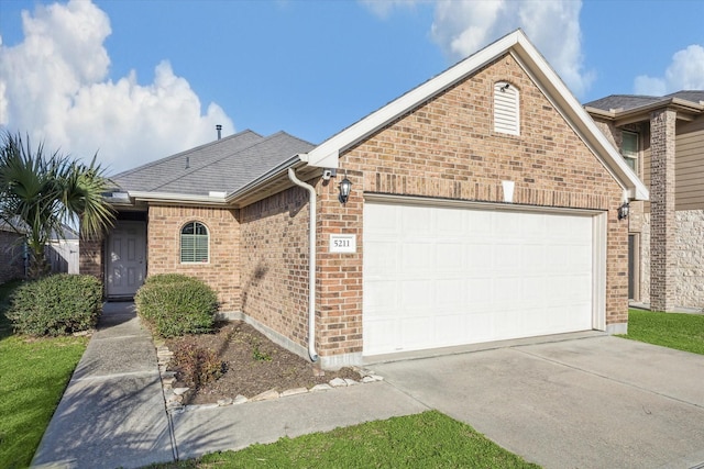 single story home with brick siding, driveway, a garage, and roof with shingles