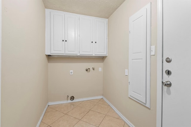 washroom featuring light tile patterned floors, hookup for an electric dryer, cabinet space, washer hookup, and hookup for a gas dryer