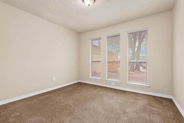 unfurnished room with dark carpet, a textured ceiling, and baseboards