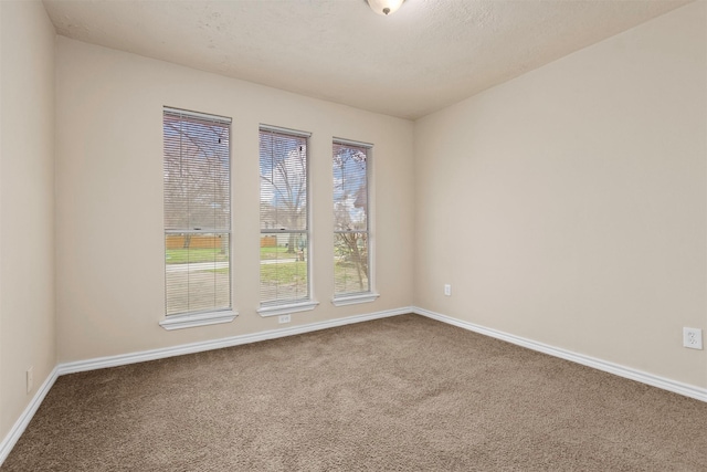 carpeted empty room with baseboards