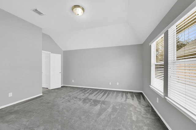 additional living space with visible vents, lofted ceiling, carpet, and baseboards