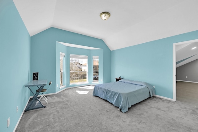 bedroom featuring baseboards, lofted ceiling, and carpet