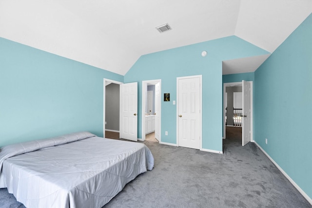 bedroom with visible vents, baseboards, carpet, vaulted ceiling, and ensuite bath