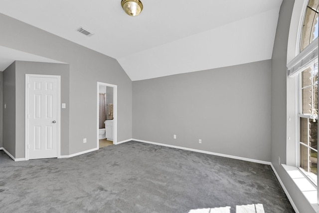 unfurnished bedroom with visible vents, connected bathroom, baseboards, carpet, and lofted ceiling