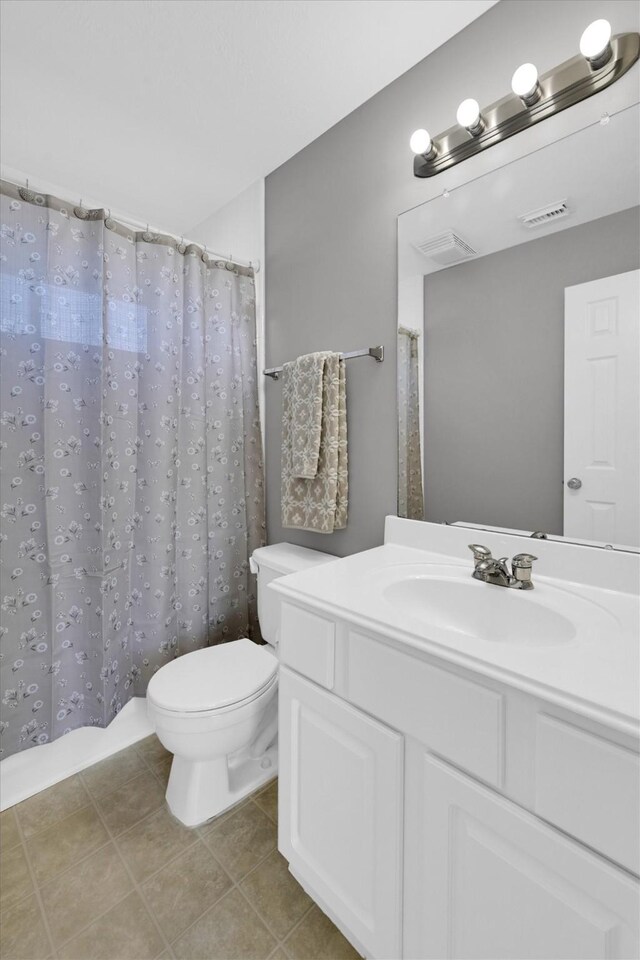 bathroom featuring vanity, tile patterned floors, toilet, and visible vents