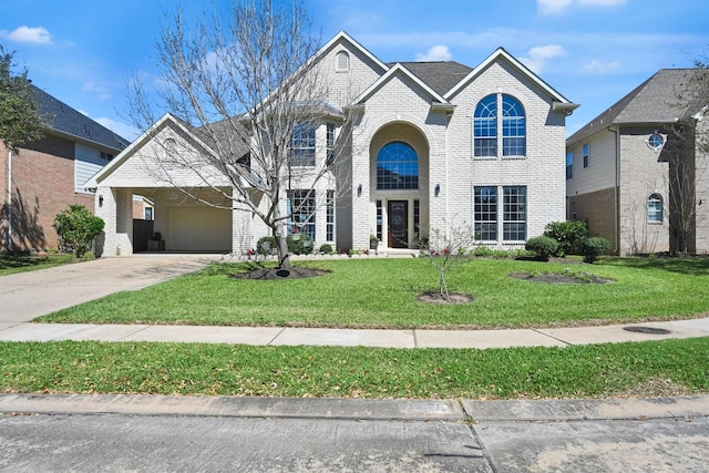 view of front of property with a front lawn, brick siding, and driveway