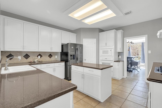 kitchen with visible vents, white appliances, white cabinetry, and a sink