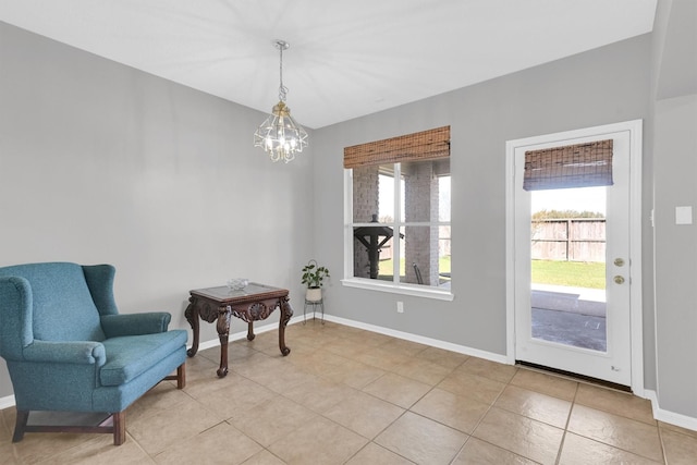 living area featuring light tile patterned flooring, baseboards, a wealth of natural light, and a chandelier