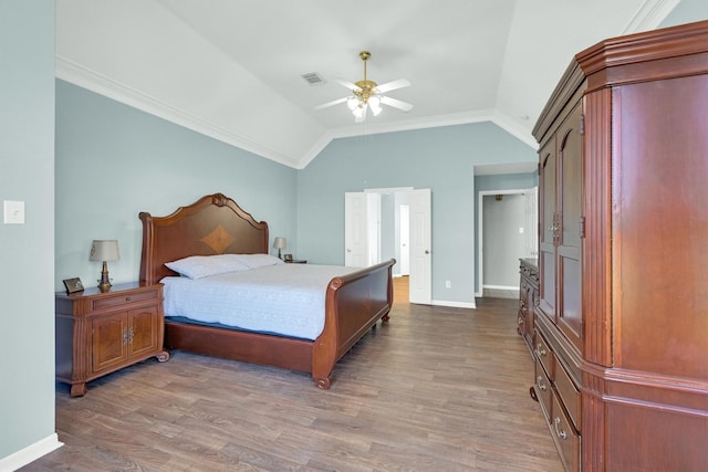 bedroom featuring visible vents, lofted ceiling, wood finished floors, and crown molding