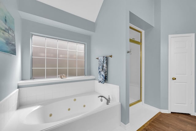 full bath featuring a shower stall, wood finished floors, a tub with jets, and baseboards