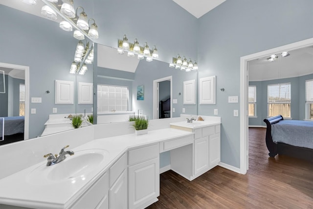 ensuite bathroom featuring double vanity, wood finished floors, ensuite bathroom, and a sink