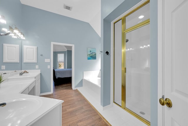 ensuite bathroom featuring a sink, visible vents, double vanity, and a shower stall