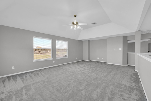 carpeted spare room featuring visible vents, a ceiling fan, baseboards, and vaulted ceiling