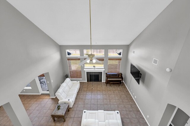 22106 Stonebriar Ln, Richmond, TX 77469 - tiled living room with ceiling fan, baseboards, visible vents, and a fireplace
