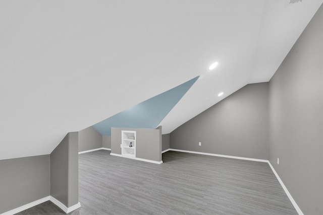 additional living space with lofted ceiling, recessed lighting, wood finished floors, and baseboards