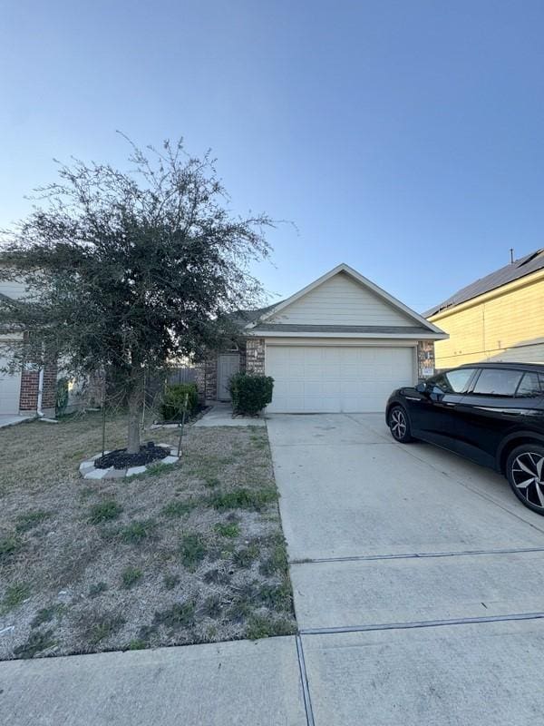 view of front facade featuring driveway, a garage, and fence