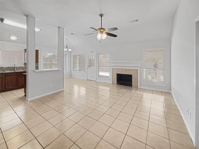 unfurnished living room featuring a sink, visible vents, plenty of natural light, and a tile fireplace