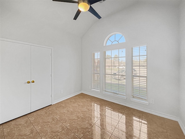 unfurnished room featuring a ceiling fan, baseboards, and high vaulted ceiling