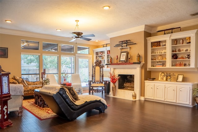 living room with dark wood-style floors, a healthy amount of sunlight, a fireplace, and crown molding