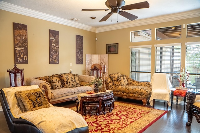 living area with visible vents, wood finished floors, ornamental molding, and a ceiling fan