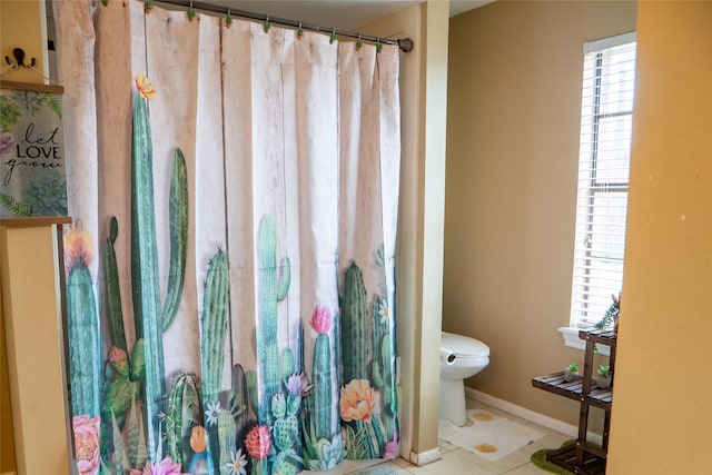 full bath with tile patterned flooring, toilet, and baseboards