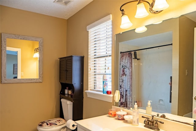 bathroom featuring visible vents, toilet, curtained shower, a textured ceiling, and vanity