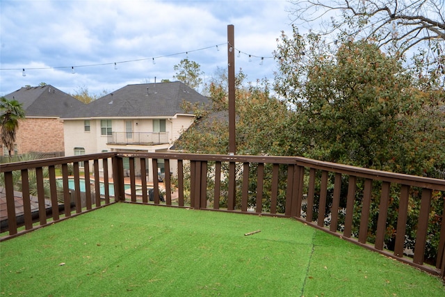 view of yard with a balcony and an outdoor pool