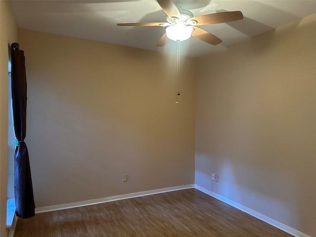 empty room featuring ceiling fan, baseboards, and wood finished floors