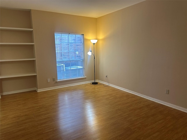 unfurnished room featuring wood finished floors and baseboards