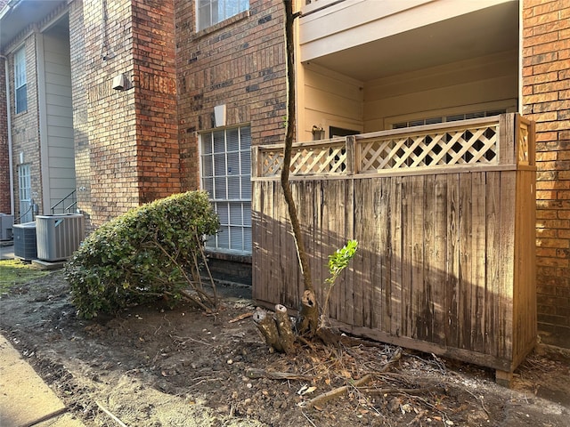 view of home's exterior featuring brick siding and central AC